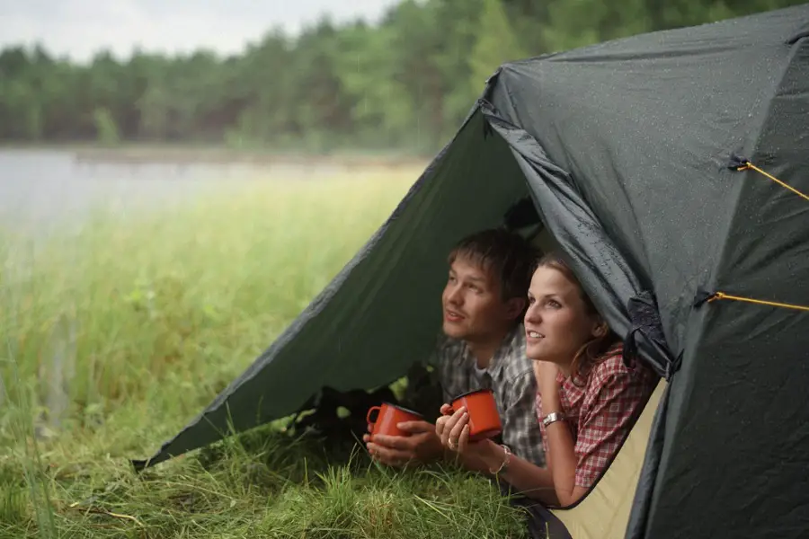 Young couple inside tent on a rainy day