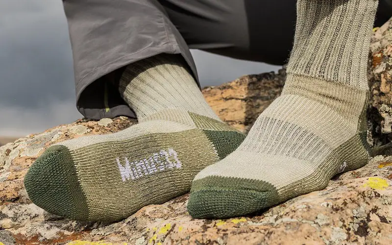 Man rests after hiking wearing just socks